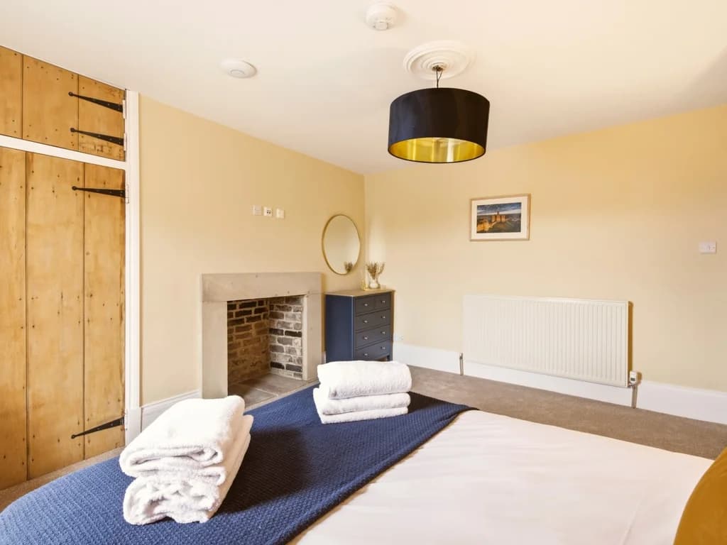 Spacious Queen bedroom with feature fireplace and wardrobe