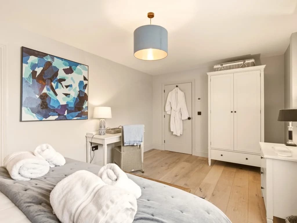 Bright super king bedroom with fitted wardrobe, dressing table and artwork