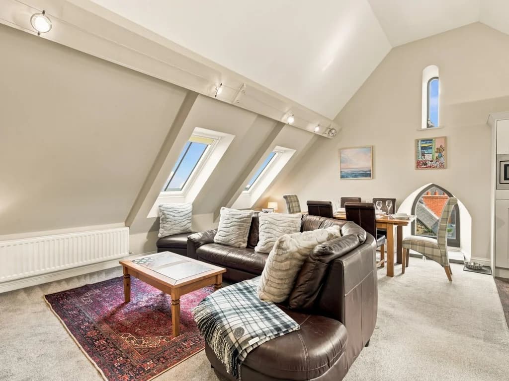 Open-plan living area with skylights, leather sofas and dining space.