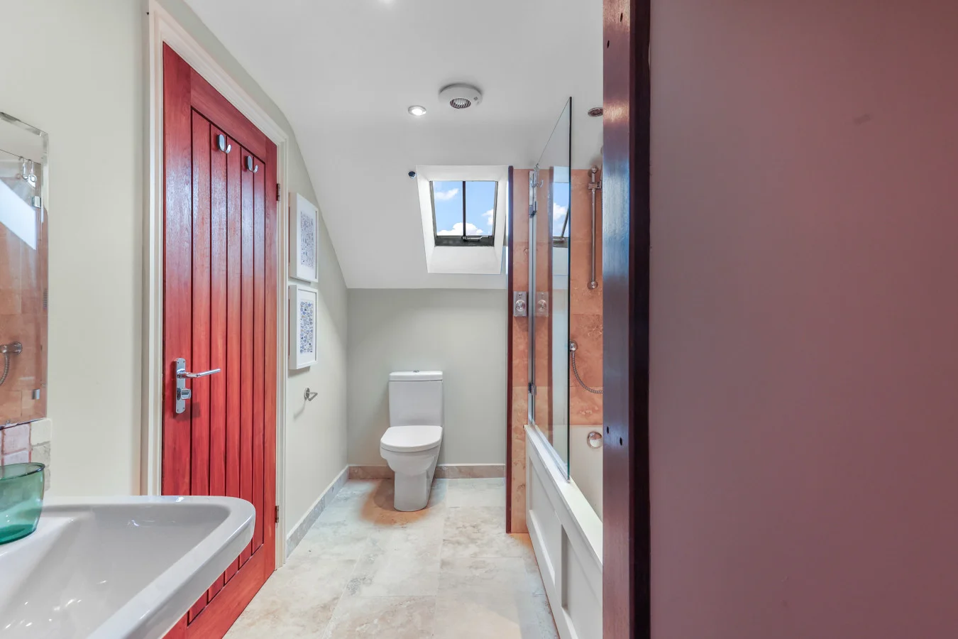 Bright en-suite bathroom with bath, shower and skylight window