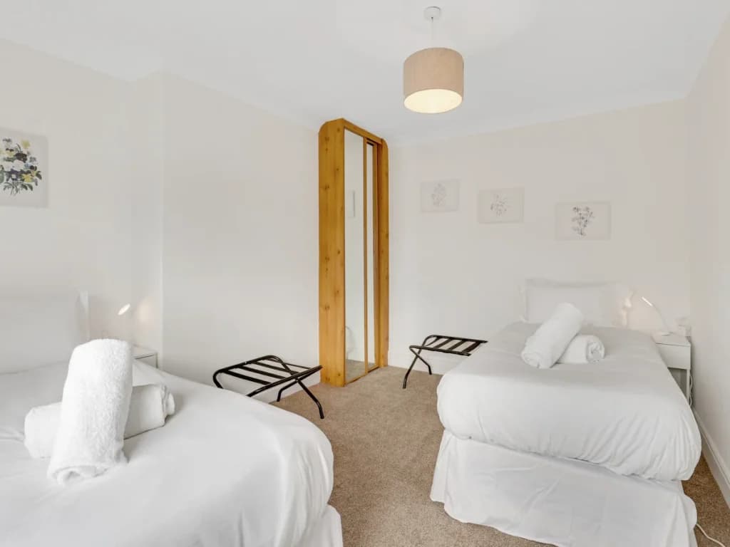 Twin bedroom with two single beds, luggage racks and hanging space