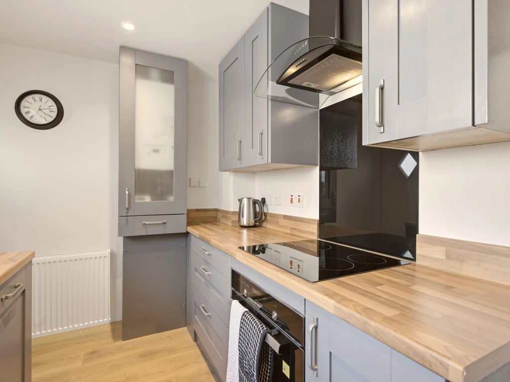 Modern kitchen with electric hob, extractor hood and wood-effect worktops