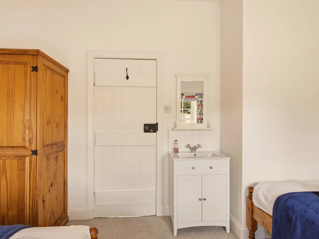 Twin bedroom with painted pine furniture and charming coastal-inspired décor