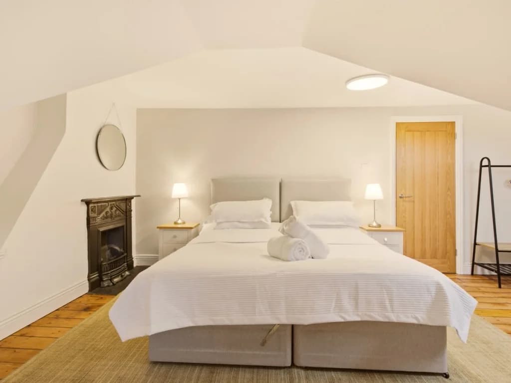 Super king-size bedroom with bedside lamps, mirror and hanging rail