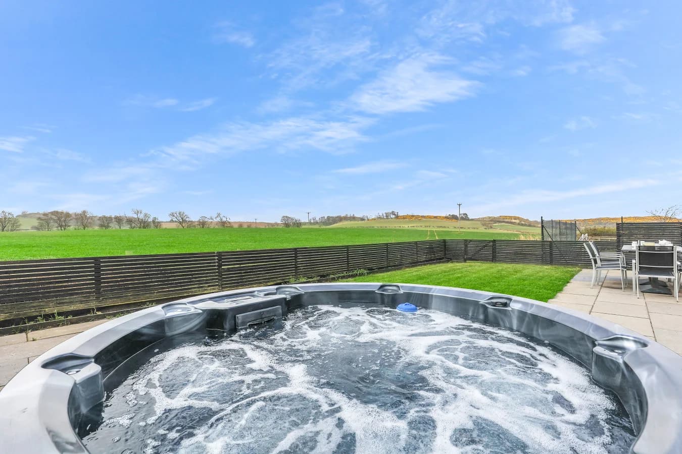 Private hot tub overlooking the enclosed garden and paddocks