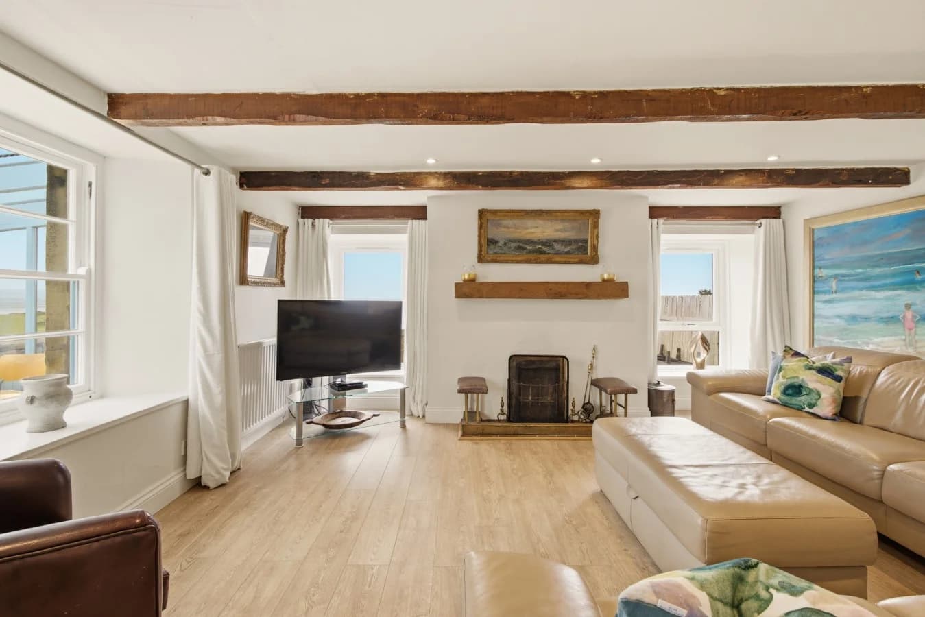 Living area with open fire, exposed beams and sea views