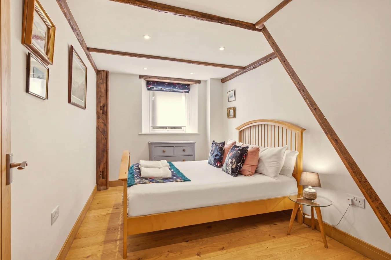 Bright bedroom with wooden bed frame and exposed timber details