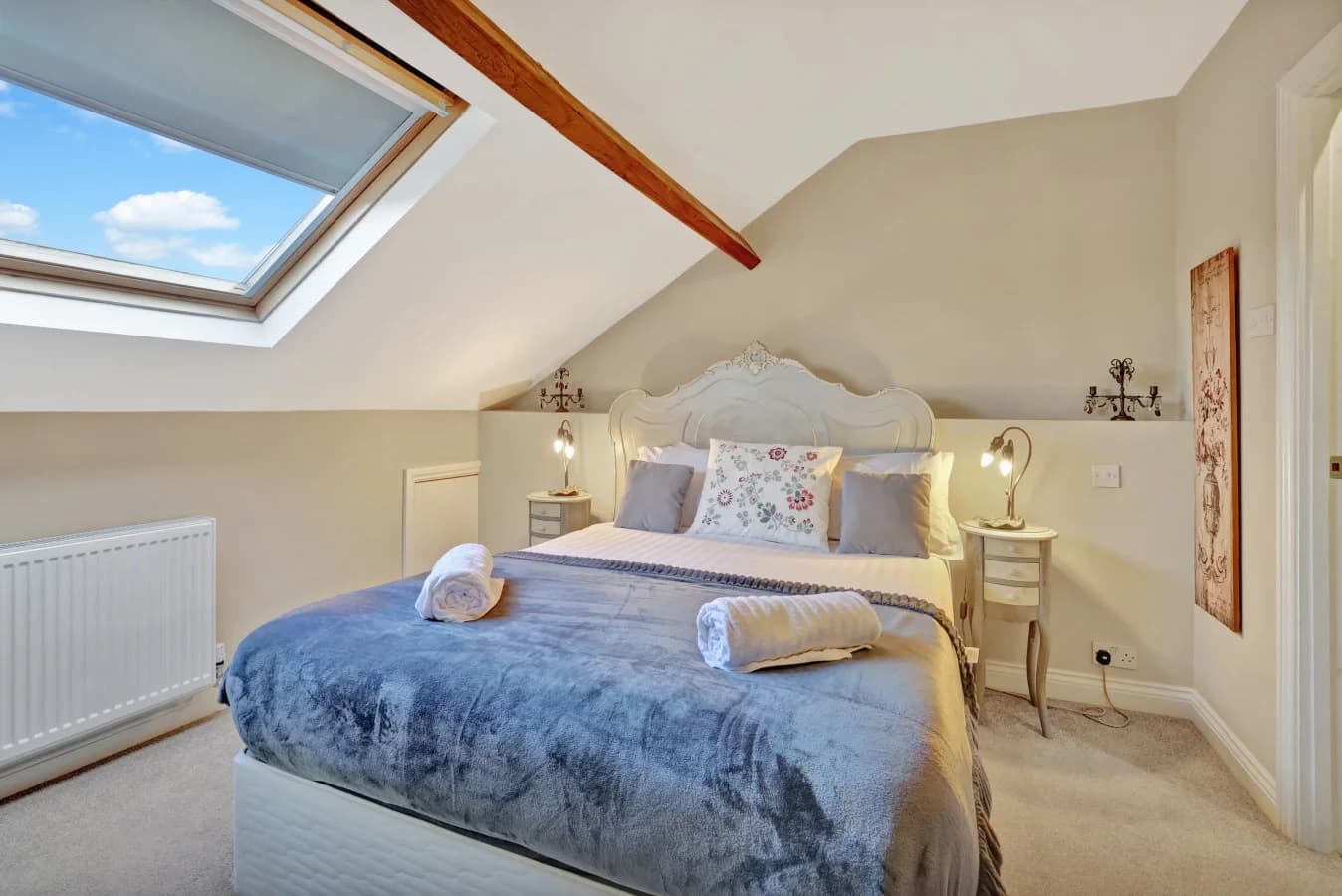 Top-floor king bedroom with skylight, exposed beam and dressing area