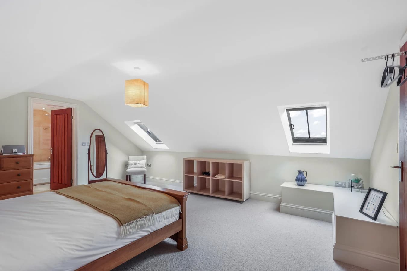 Bright king bedroom with skylights, seating area and storage