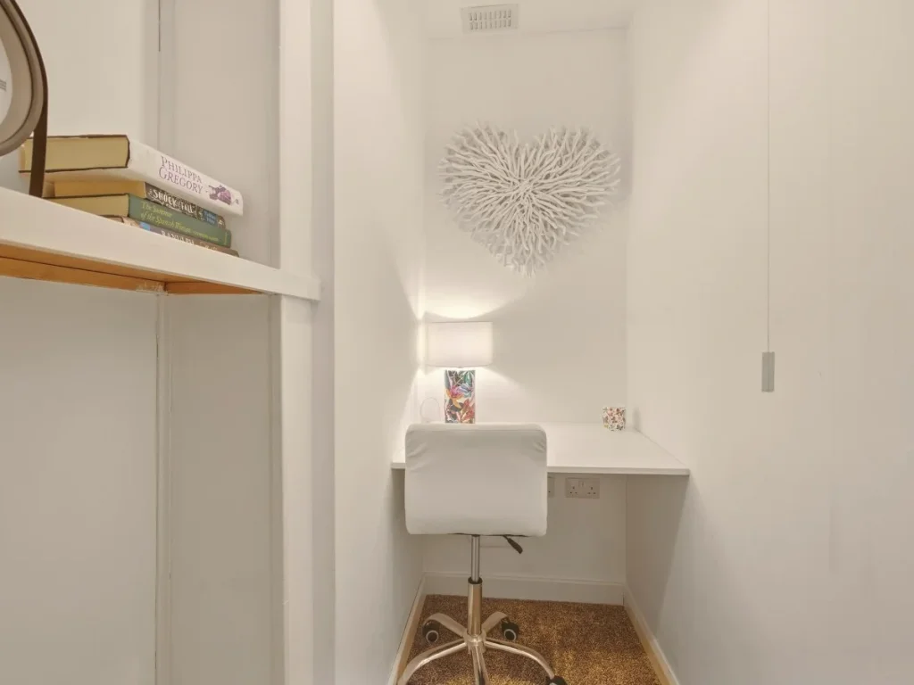Dedicated study area with desk, chair, shelving and soft task lighting.