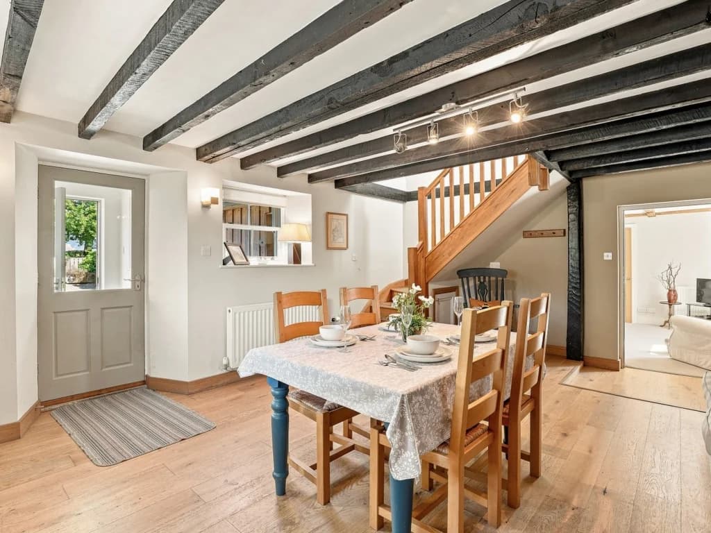 Dining space with exposed ceiling beams and cottage-style details