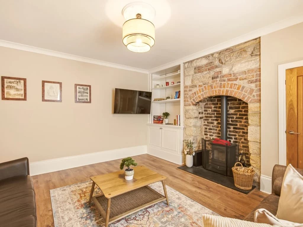 Characterful living room with feature fireplace, wood-burning stove and Smart TV.