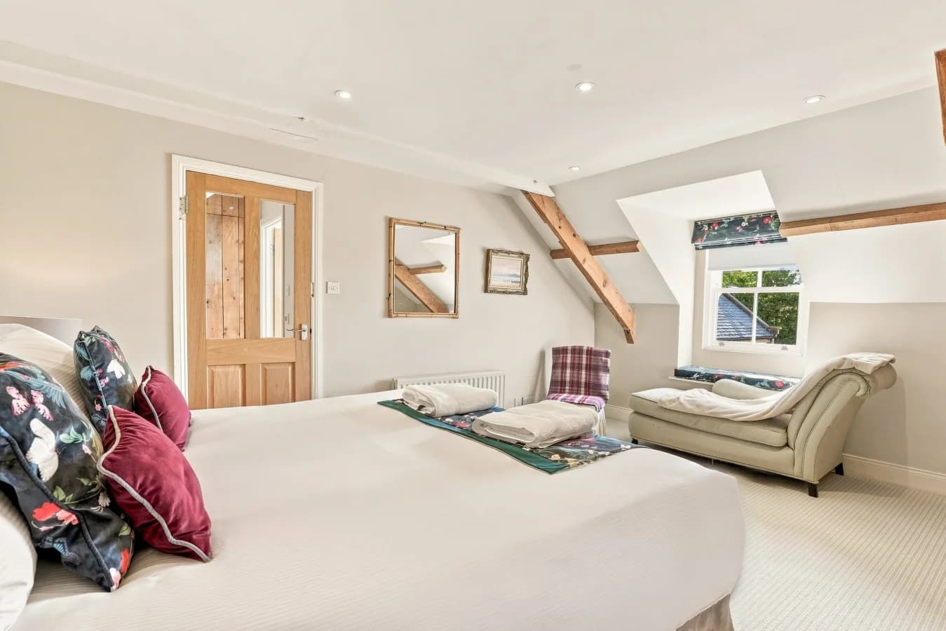 Spacious king bedroom with seating area and exposed timber beams
