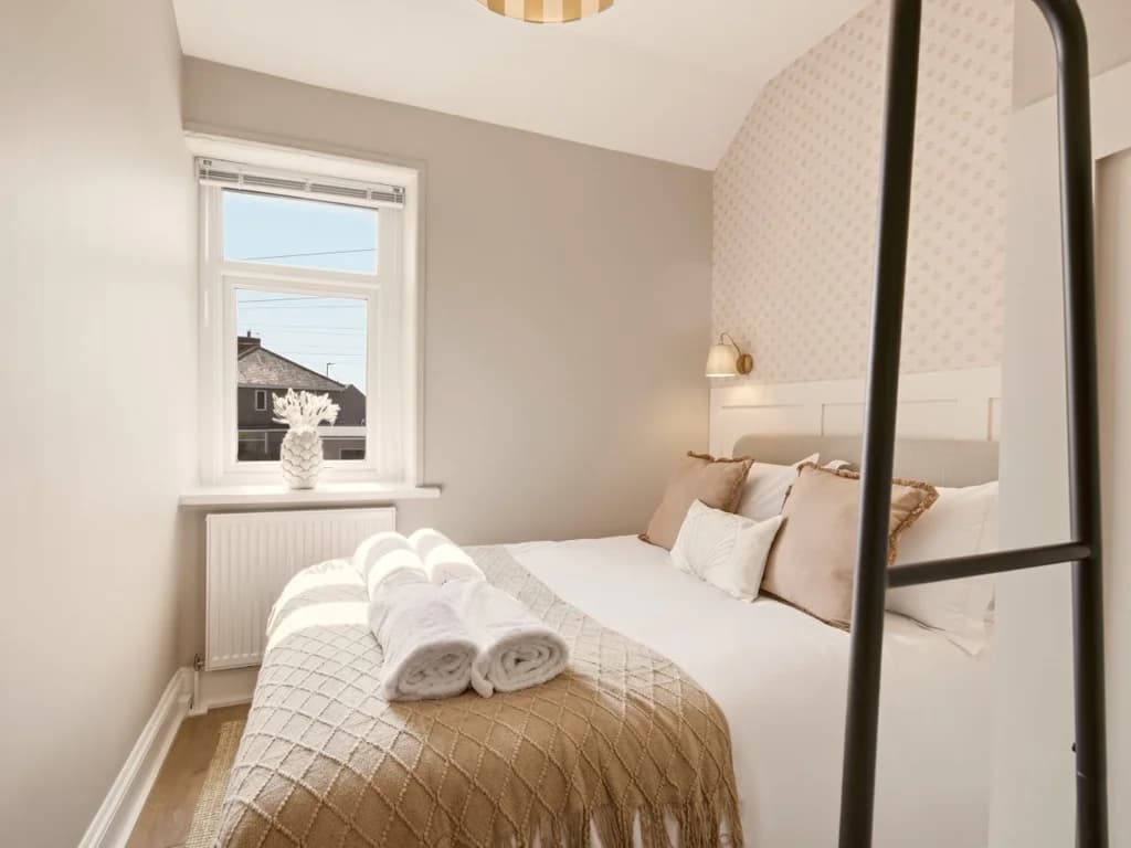 Double bedroom with panelled headboard and soft neutral décor