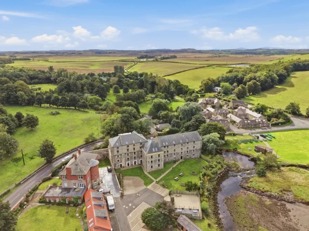 Aerial view of historic Waren Mill surrounded by open countryside