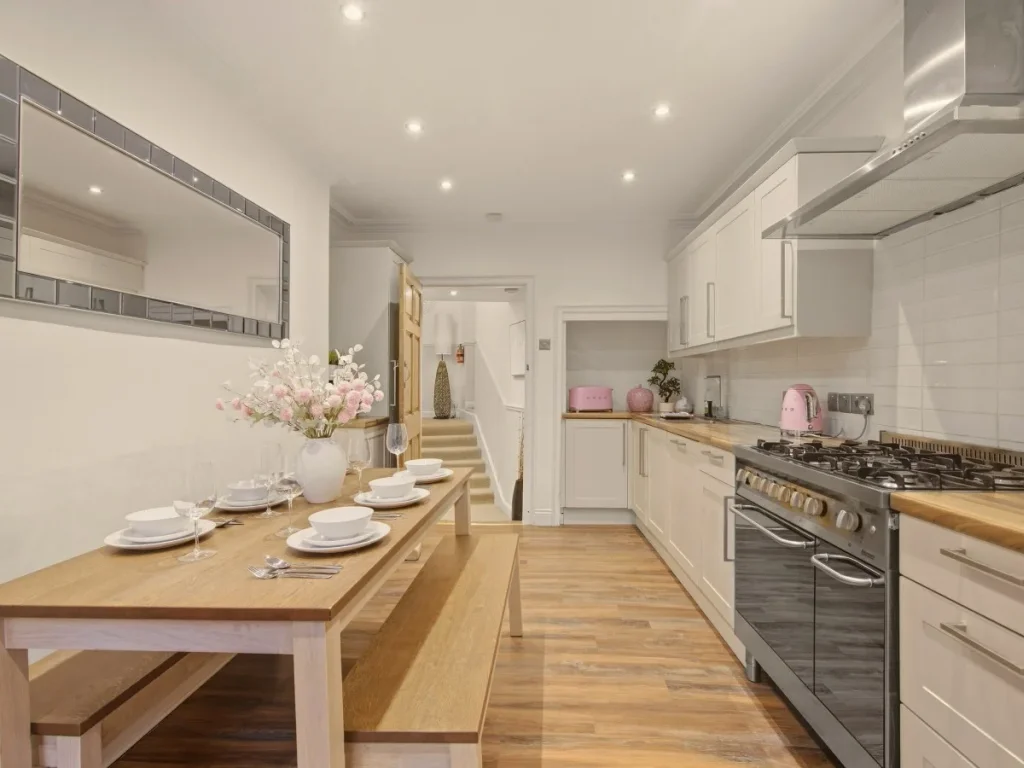 Well-equipped kitchen and dining area with wooden table and bench seating.