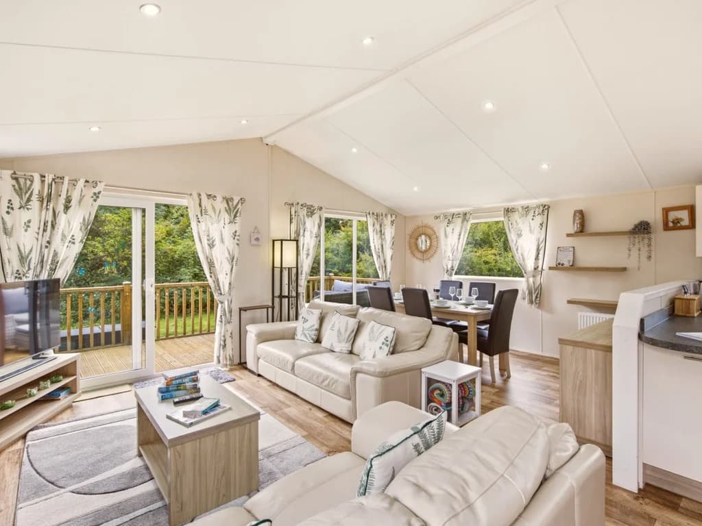 Bright open-plan living and dining area with doors onto the decking