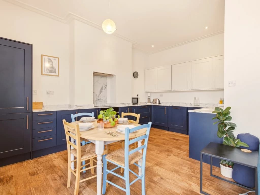 Dining area beside the modern kitchen with integrated appliances.