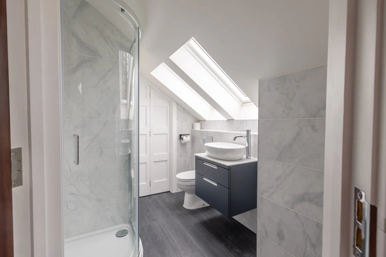 En-suite shower room with skylights and marble-effect wall tiles