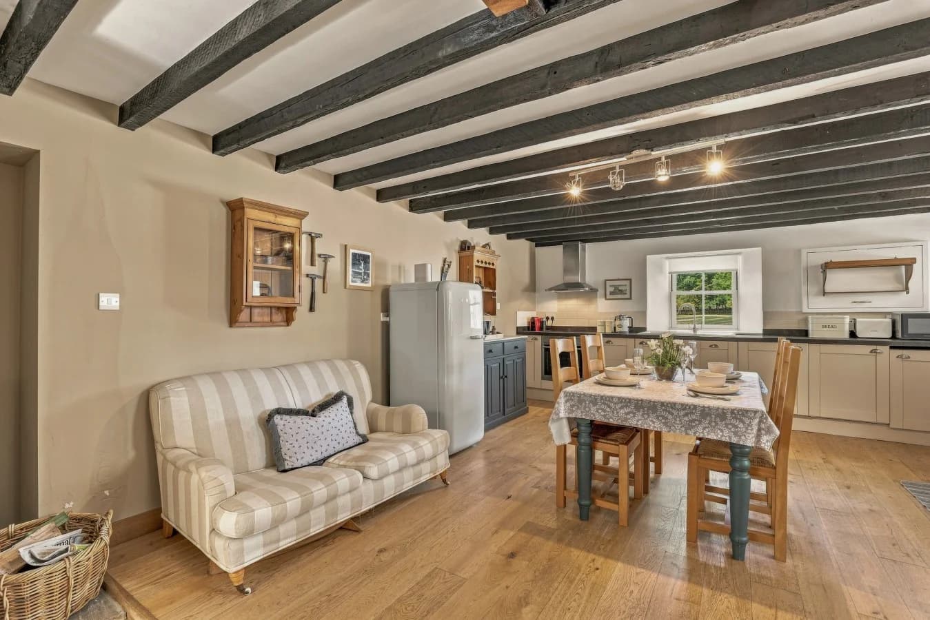 Kitchen and dining area with exposed beams and wooden flooring
