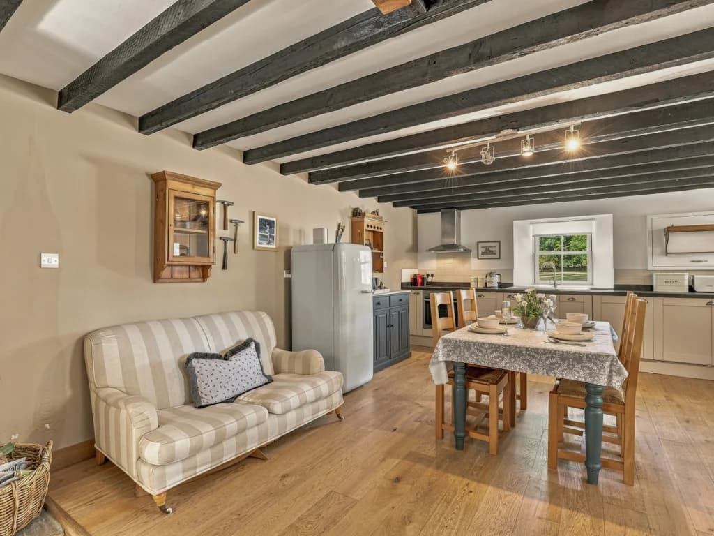 Kitchen and dining area with exposed beams and wooden flooring