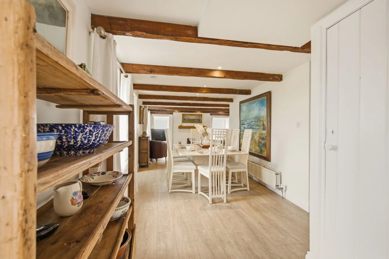 Dining area with exposed beams and oak flooring
