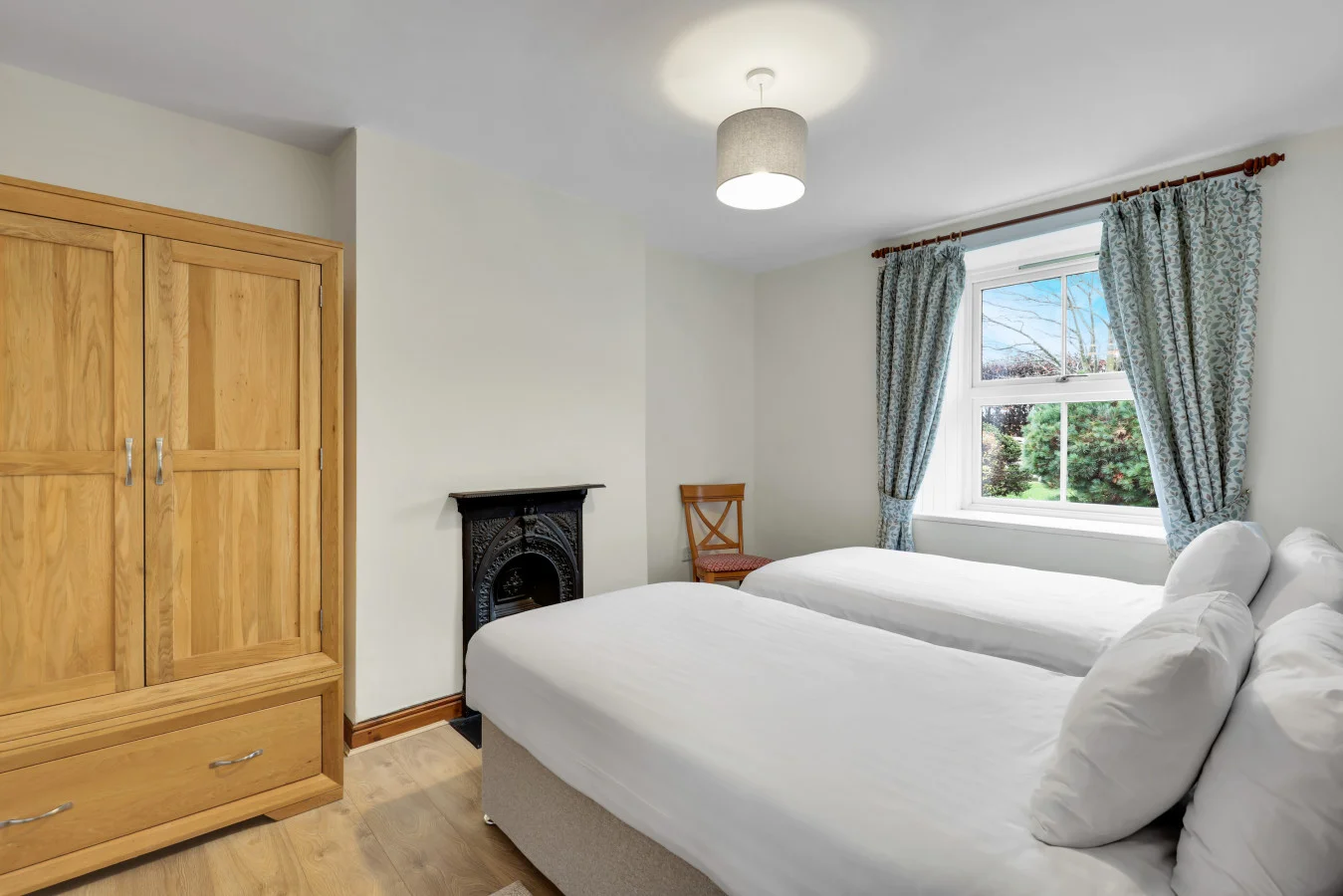 Twin bedroom with period fireplace and views across the grounds