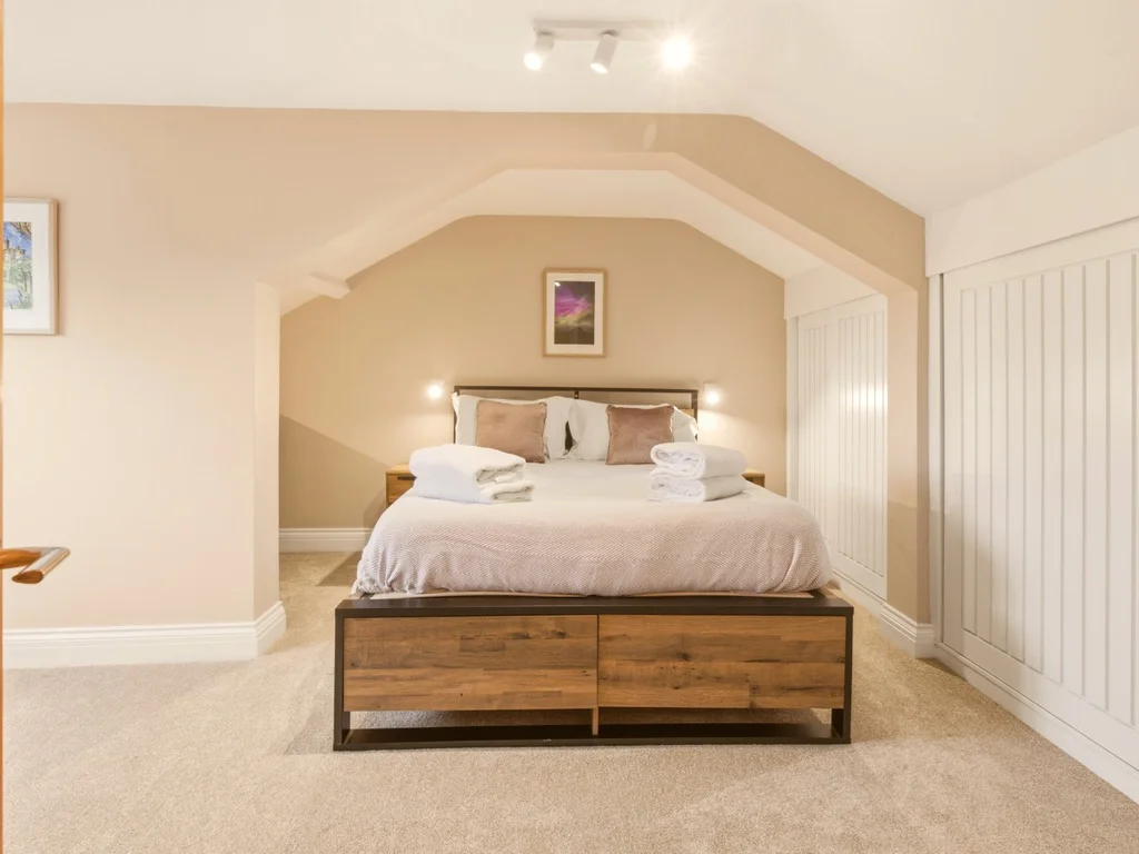 Generous top-floor king bedroom with built-in wardrobes and en-suite access.