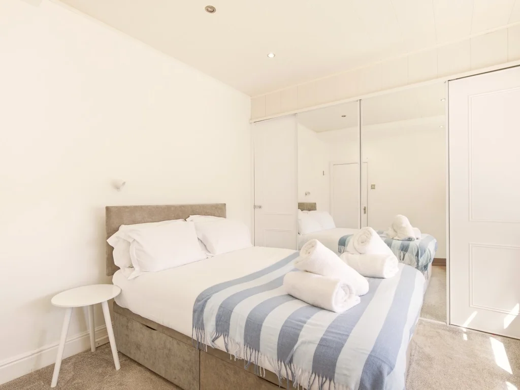 Double bedroom with mirrored wardrobes and soft neutral décor.