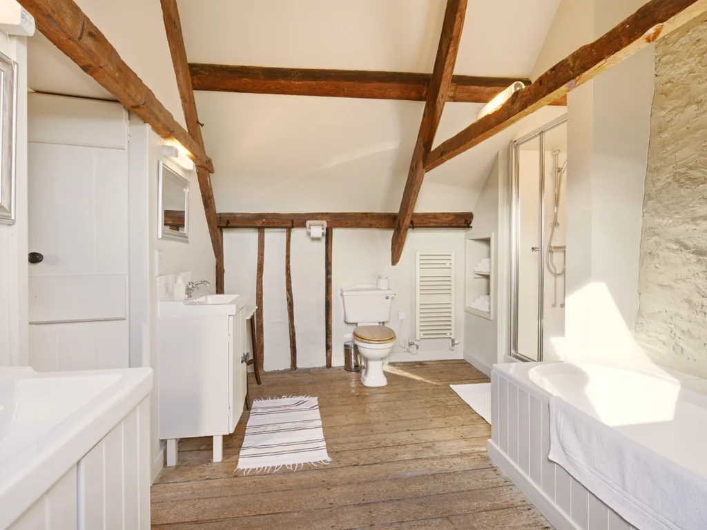 Ensuite bathroom with bath, shower and traditional stone walls