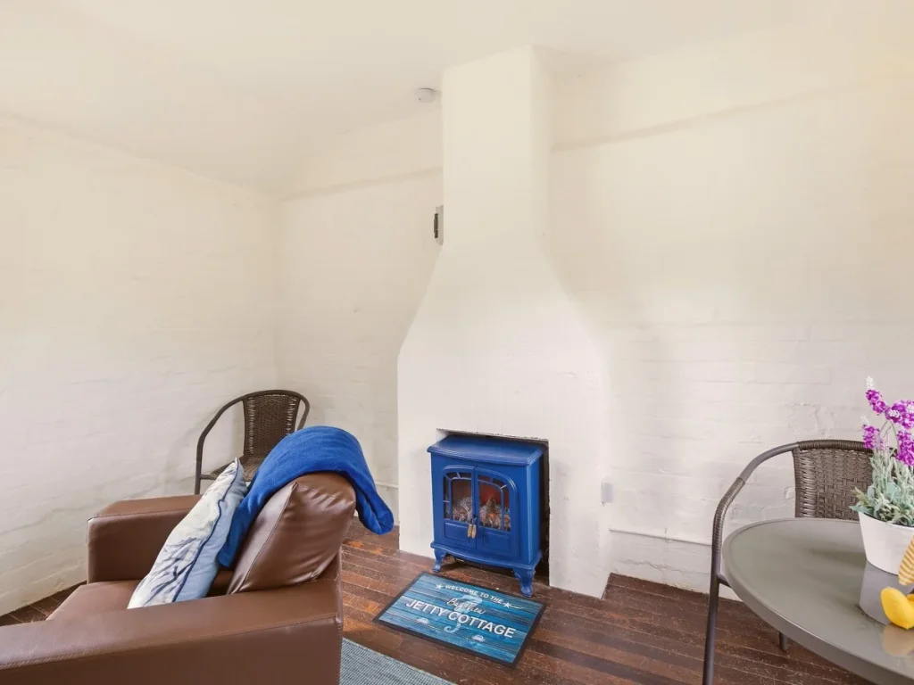 Jetty Cottage interior with seating, dining table and wood-burning stove