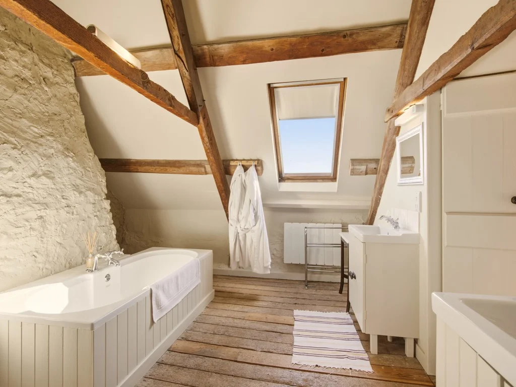 Freestanding bath beneath the sloping ceiling in the ensuite