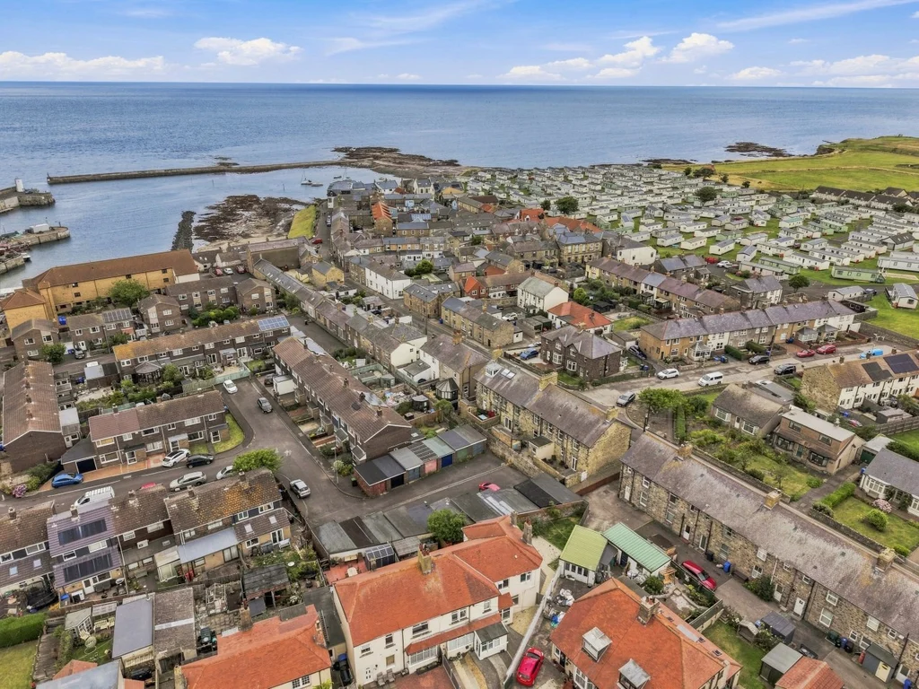 Aerial view of Seahouses harbour, coastline and surrounding village.