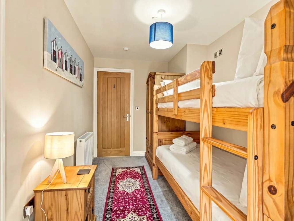 Bunk bedroom with solid wooden bunks and bedside table.