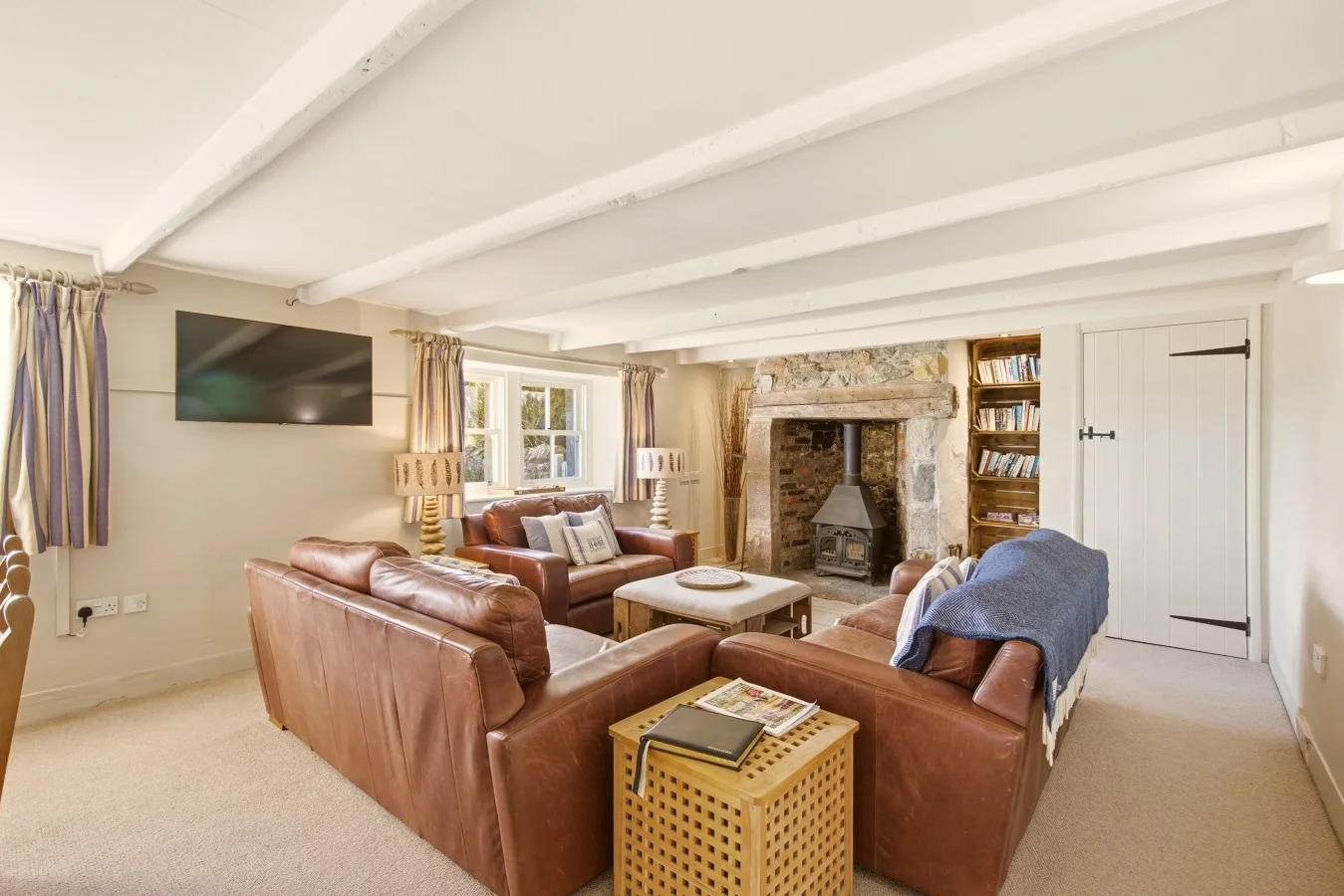 Sitting room with leather sofas and a traditional inglenook fireplace