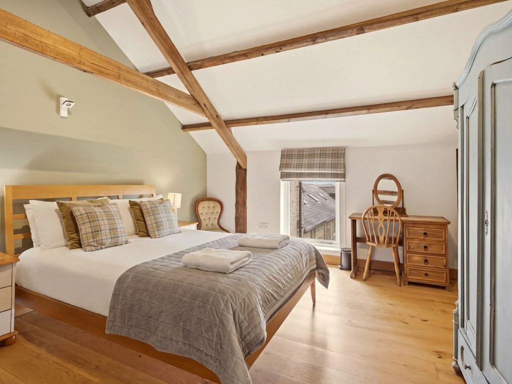 King-size bedroom with exposed beams, wardrobe and dressing table