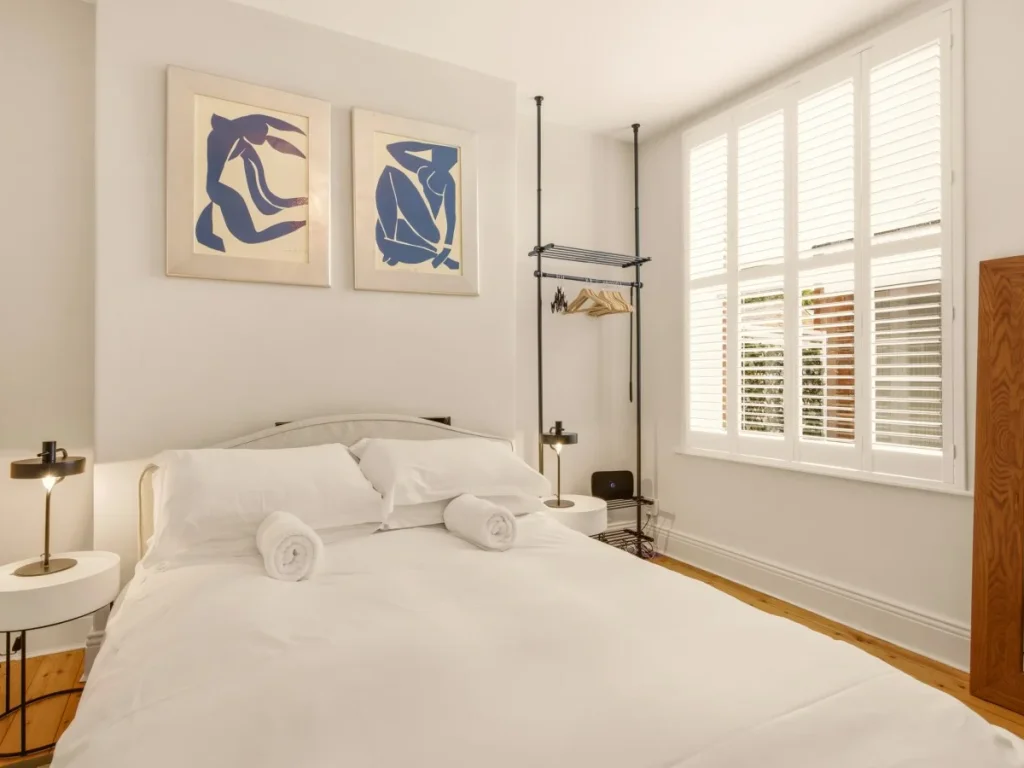 King-size bedroom with bedside tables, hanging rail and large window