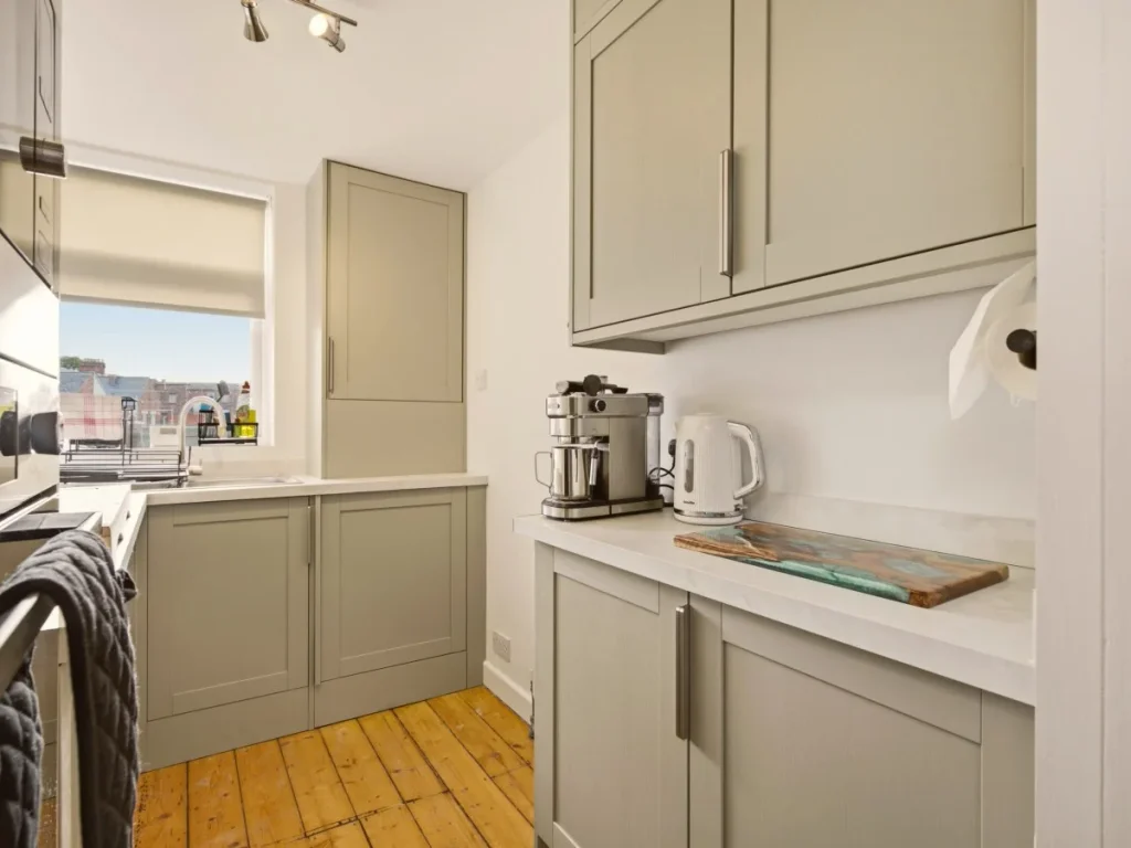 Bright kitchen with coffee machine, kettle, ample storage and worktops