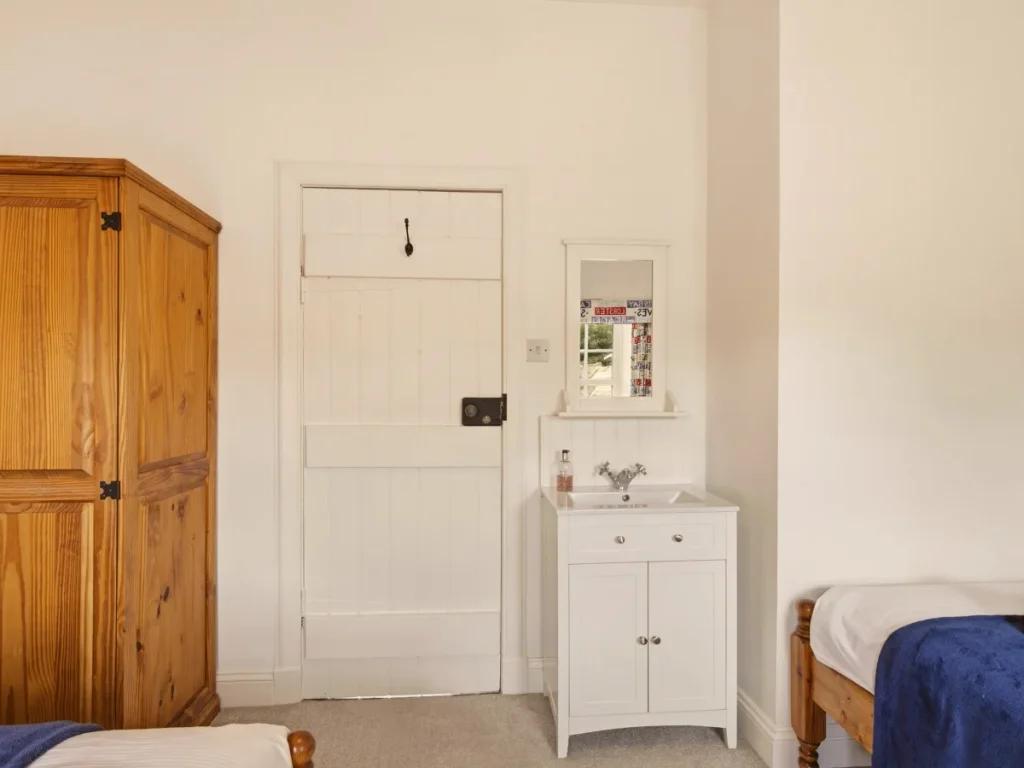 Twin bedroom with painted pine furniture and charming coastal-inspired décor