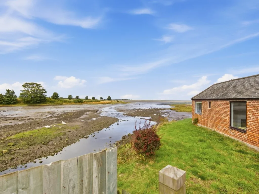 Waterside setting beside Waren Burn with open views across Budle Bay