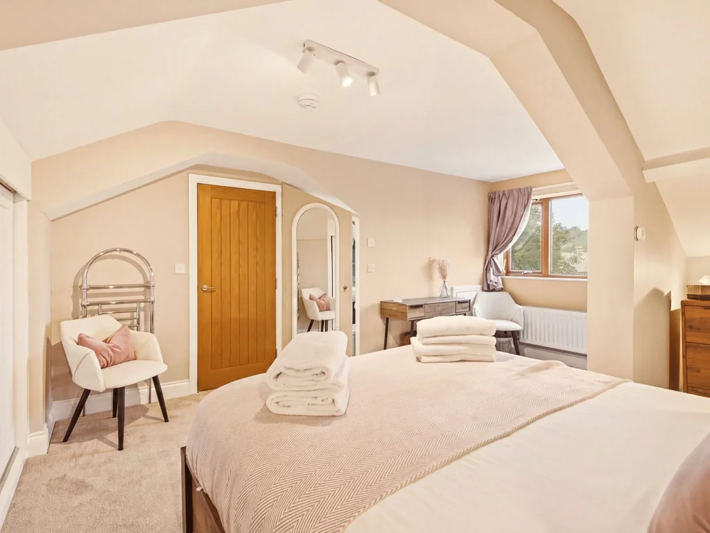 Spacious top-floor king bedroom with en-suite and dressing area.
