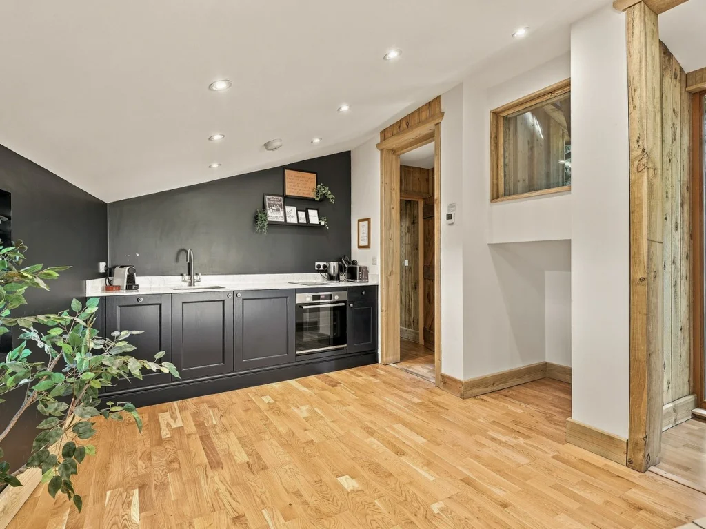 Well-equipped kitchen with dark cabinetry and wooden flooring