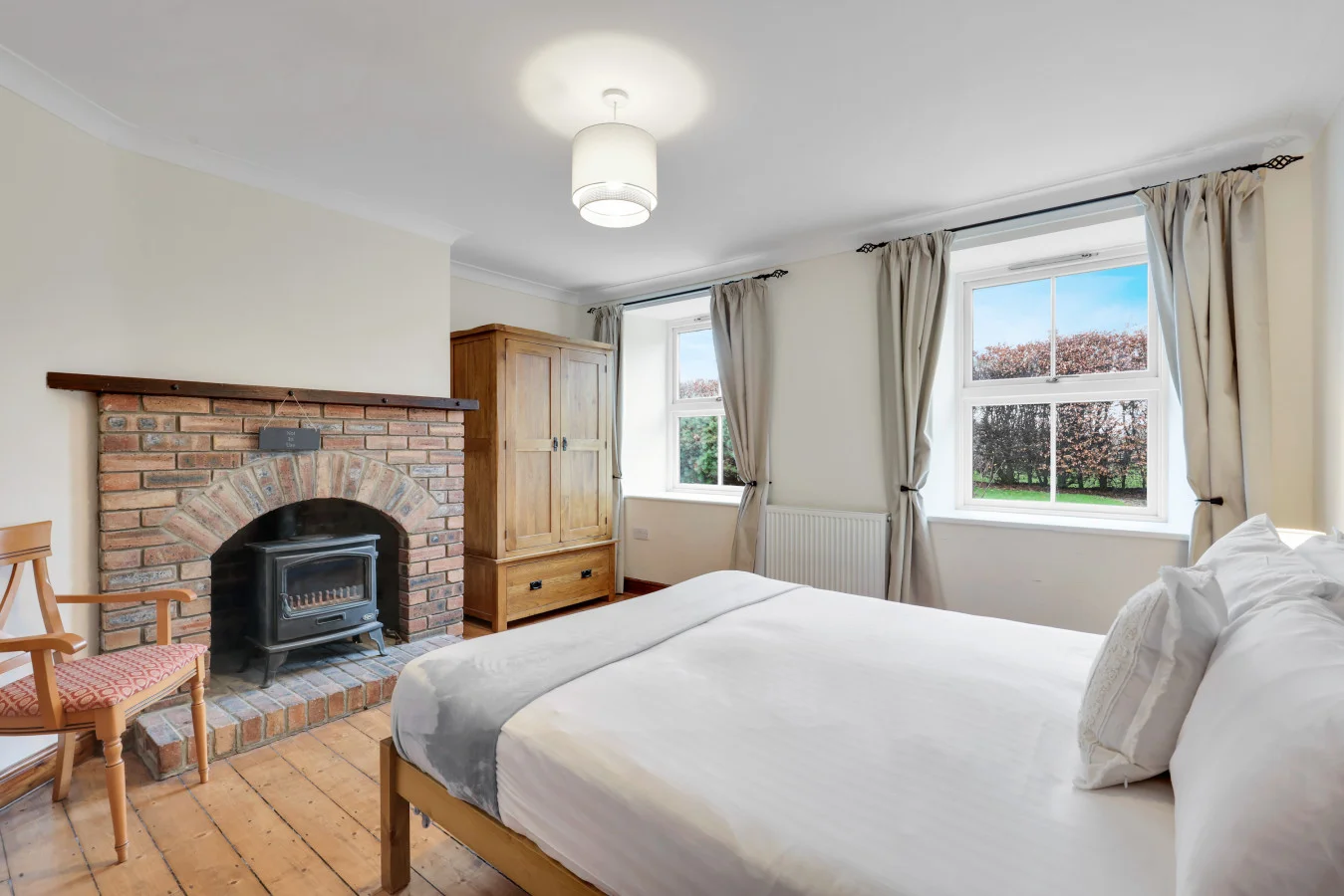 Ground-floor king bedroom with exposed brick fireplace feature