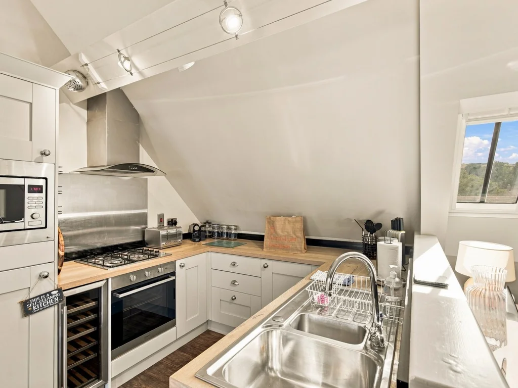Open-plan dining area beneath vaulted ceilings and feature windows.