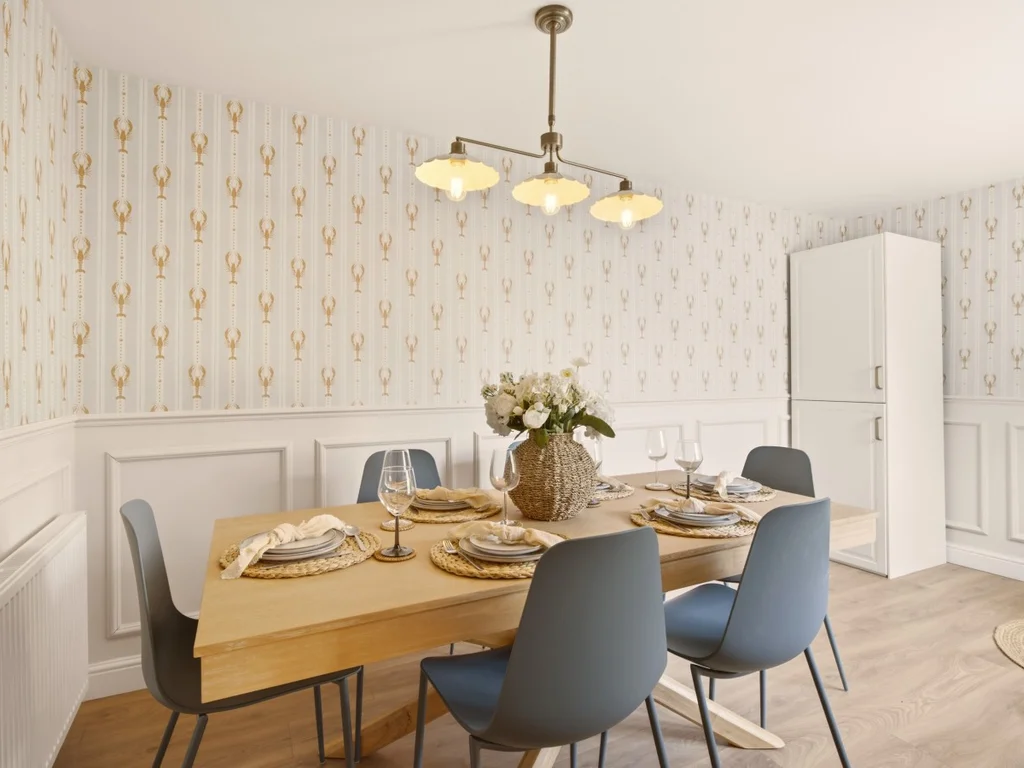 Dining room with wooden table, patterned wallpaper and seating for six