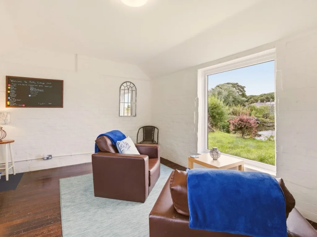 Jetty Cottage lounge with waterside outlook and comfortable seating