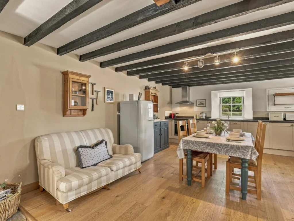 Kitchen and dining area with exposed beams and wooden flooring