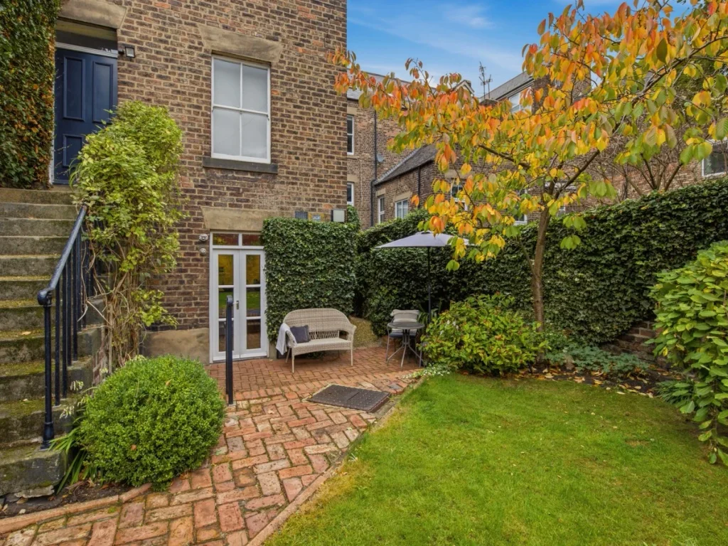 Enjoy the enclosed garden with lawn, shrubs and a brick patio