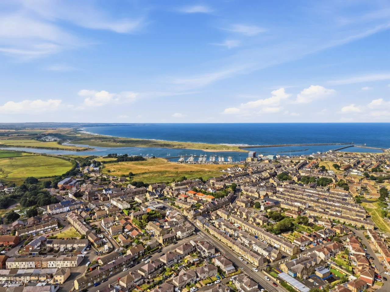 Aerial view of Amble harbour, marina and Northumberland coastline.