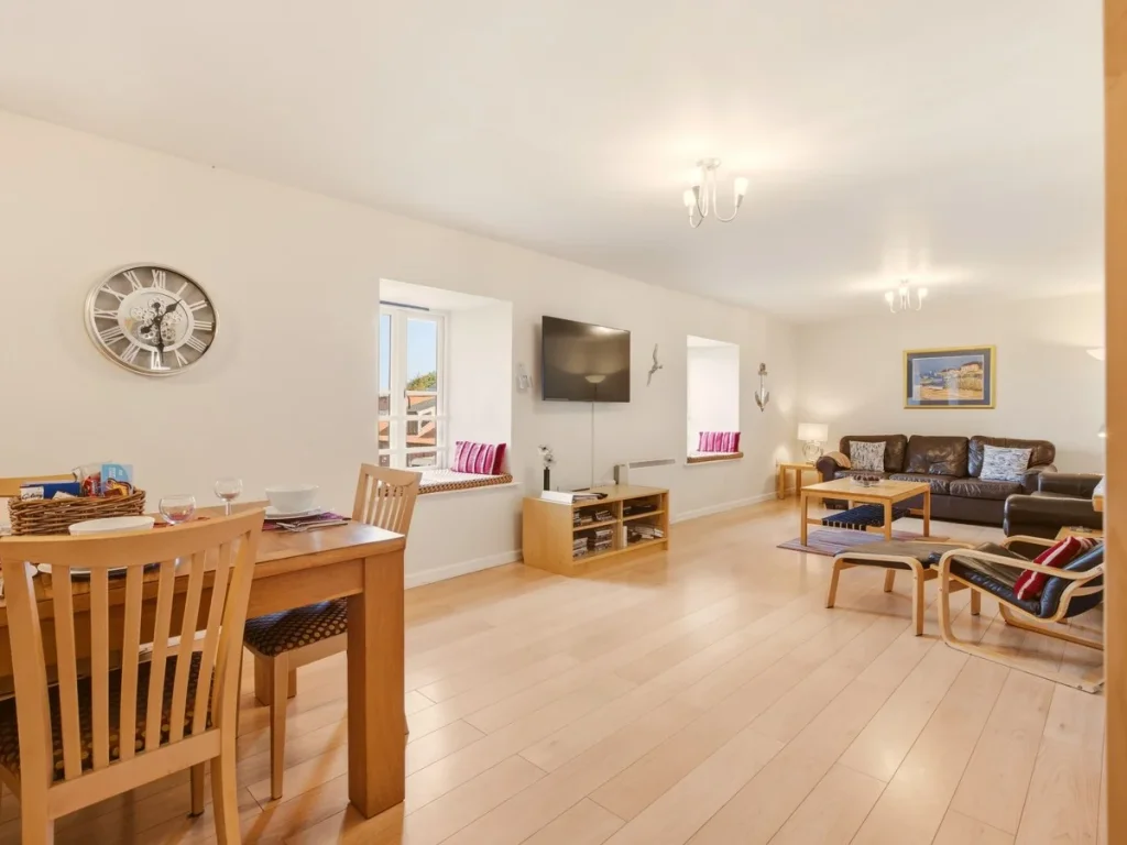 Open-plan dining and living area with bay views and comfortable seating